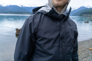 the rei rainier rain jacket being worn beside a lake in washington state