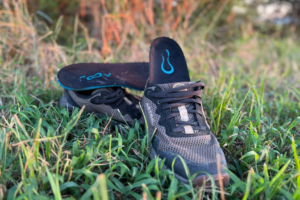 Groov Custom Insoles displayed with trail running shoes in grass