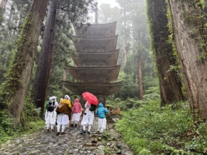 hikers standing at the base of a Pagoda in the forest