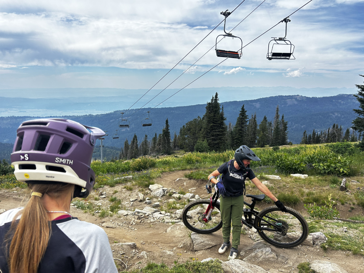 woman with bike helmet on watches instructor with mountain bike