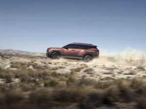 A copper-colored 2027 Hyundai Tucson XRT drives through the desert.