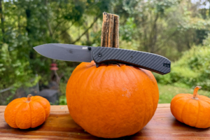 Open Lander 7 EDC knife resting across a pumpkin outdoors