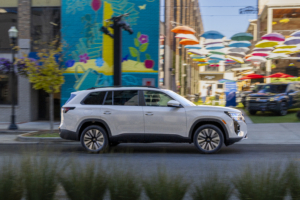 A white 27 VW Atlas drives past an umbrella-filled alley