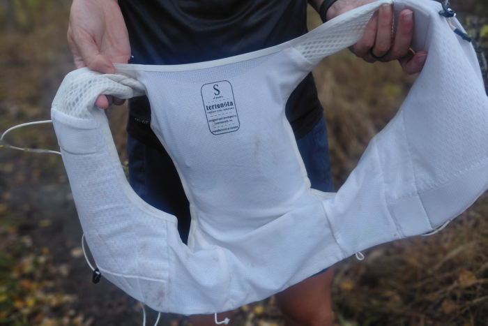 Inside view of the white running vest showing breathable mesh fabric and sizing label