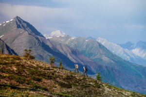 Two backpackers hike across a mountain slope in Alaska’s Ambler Road corridor