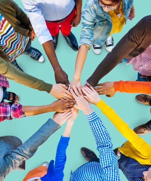A diverse group of children holding hands in unison, building community by collaborating together