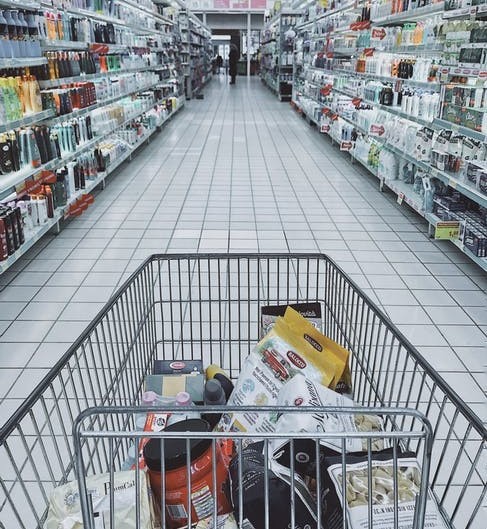 A full shopping cart in a grocery store