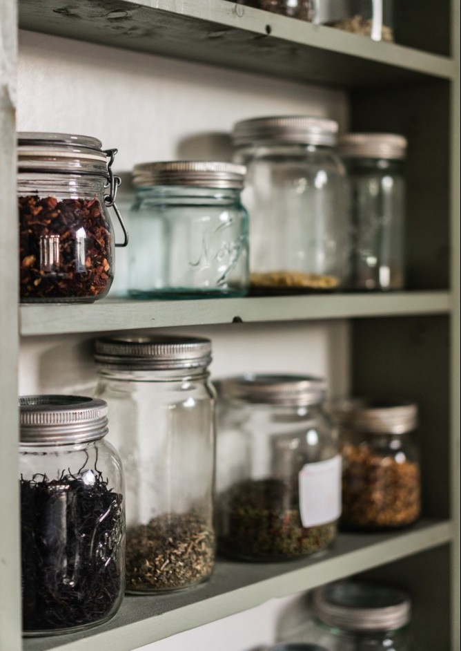 Jars of dry goods on a pantry shelf.