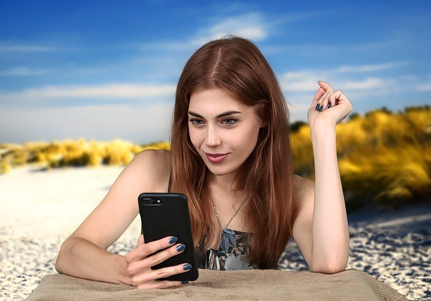 Online Dating tips for men, image shows a woman looking at her phone