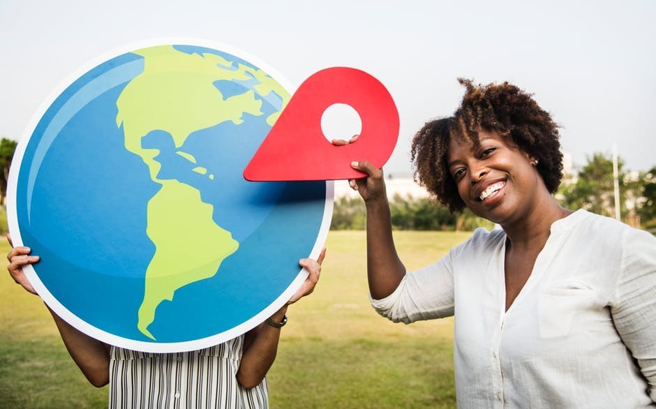 woman holding location pin on world map