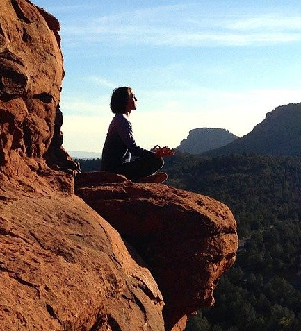 Lady meditating on cliff