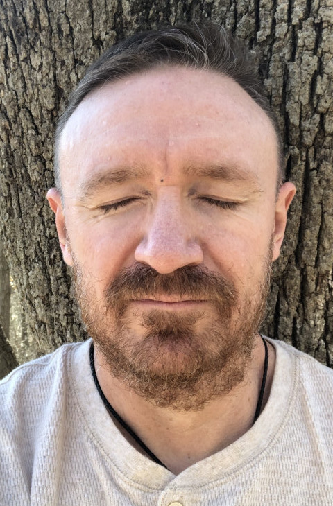 Closed eyes, leaning against a tree