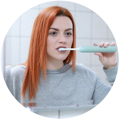 A red haired woman brushing her teeth