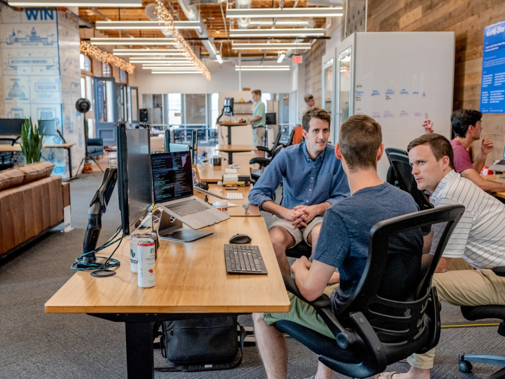 People discussing in a large clear office to mean network marketing People discussing in a large clear office to mean network marketing
