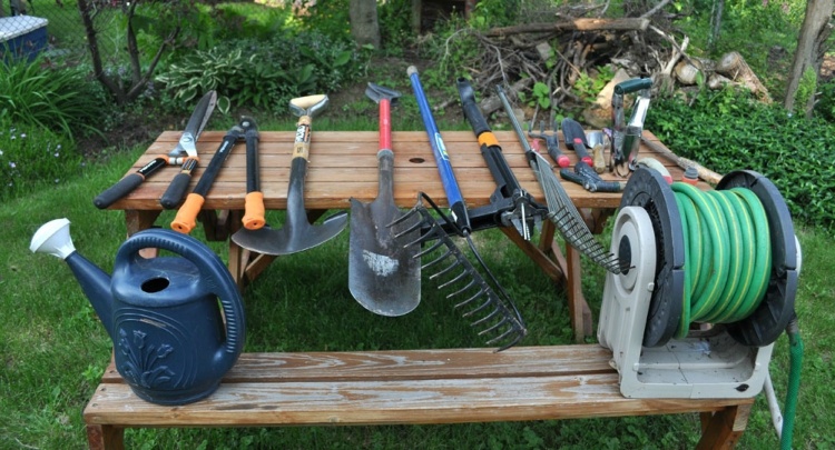 Gardening tools lined up on picnic table