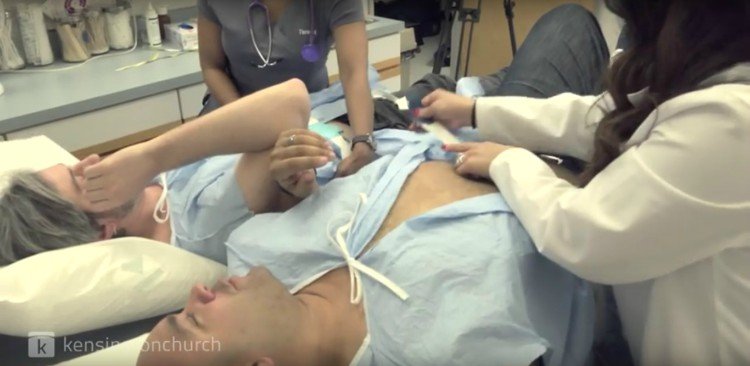 Men getting connected to contractions simulator.