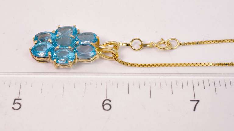 Seven Beautiful Blue Topaz Stones Set in a 14k Gold Pendant Looped with A 14k Gold Box Chain