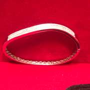 LADIES 14K WHITE GOLD AND DIAMONDS TWISTED DESIGN BANGLE BRACELET.