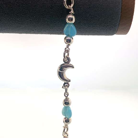 Sterling silver bracelet with light blue heart charms and silver moon and round bead charms.