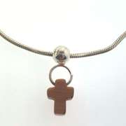 Sterling silver bracelet with one silver bead and an orangish/brown cross charm