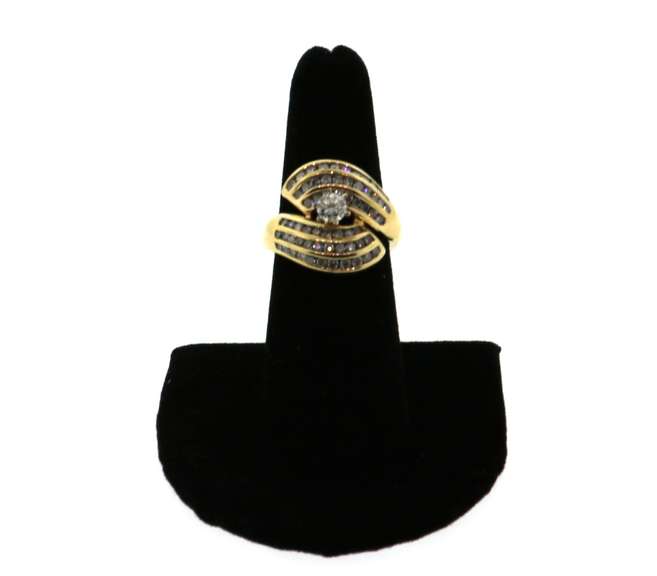Phenominal Round Diamond Centerpiece clutched by triple row Channel Set Diamonds on a 14k Gold Band