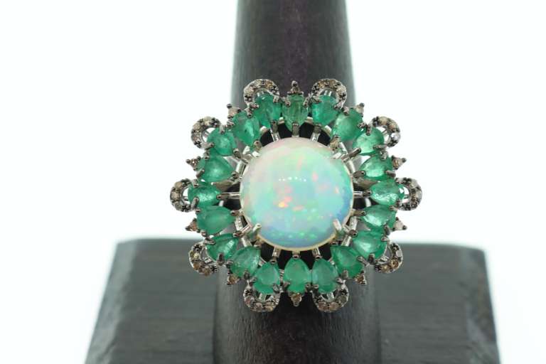 Mesmerizing Opal Ring surrounded by Emeralds and Diamond Accents