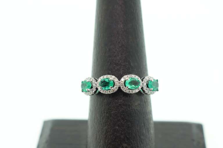 Mesmerizing Four-Stone Emerald 18k White Gold Ring edged with Diamonds