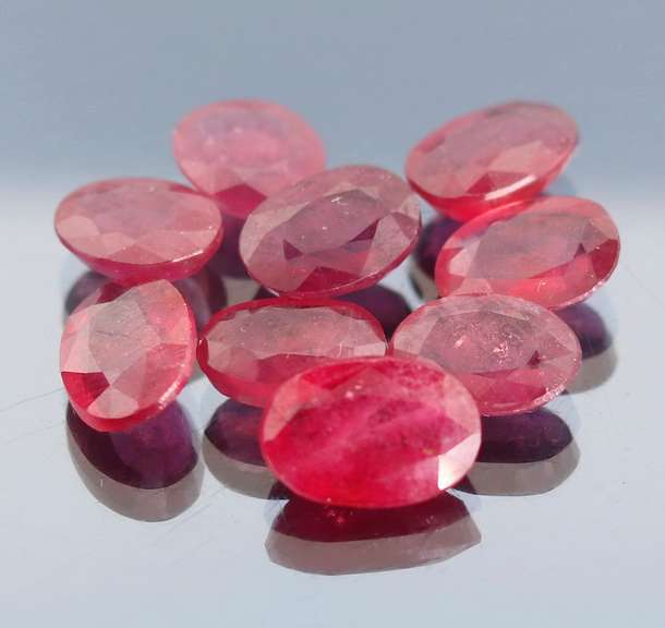 Vibrant 42.97ct oval cut reddish pink Ruby set