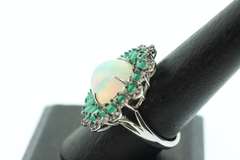 Mesmerizing Opal Ring surrounded by Emeralds and Diamond Accents
