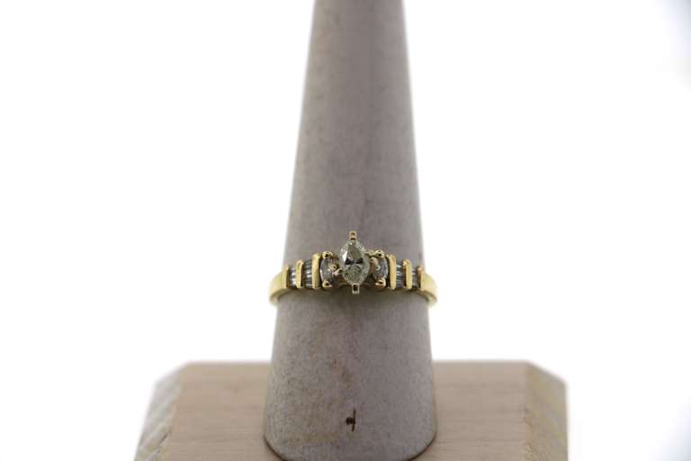 Oval Diamond Ring beset by Baguette Diamonds on a 14k Gold Band