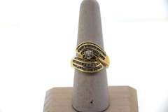 Phenominal Round Diamond Centerpiece clutched by triple row Channel Set Diamonds on a 14k Gold Band