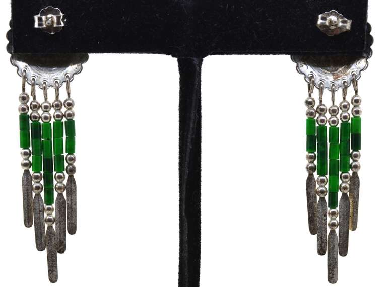 Silver Earrings With Green Beads Dangling From Them