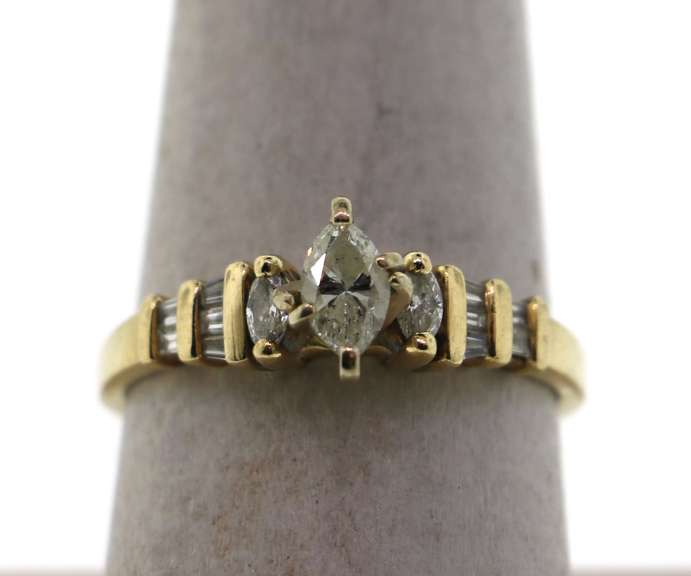Oval Diamond Ring beset by Baguette Diamonds on a 14k Gold Band