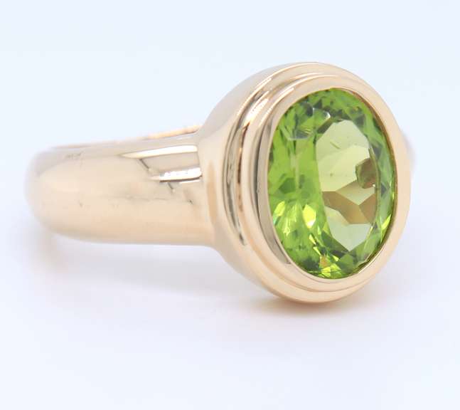 Attractive Yellow Gold oval Peridot Bezel Set Ring