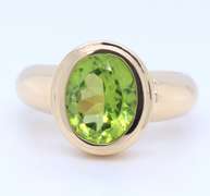 Attractive Yellow Gold oval Peridot Bezel Set Ring