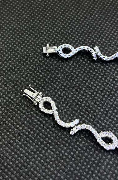 STUNNING 3.50 CARATS T.W. ROUND PAVÉ SET LEO TENNIS BRACELET IN 18K WHITE GOLD