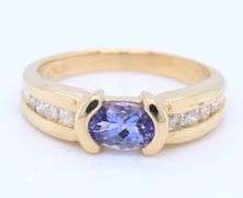 Attractive Yellow Gold oval Tanzanite and Side Channel Set Diamond Ring
