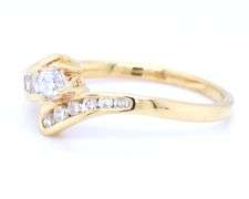 18kt Yellow gold round brilliant cut and baguette diamond bypass ring