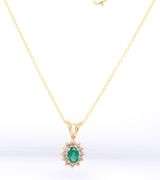 14kt Yellow gold oval Emerald and diamond halo pendant on chain necklace