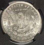 1885 O Brilliant Uncirculated Morgan $ NGC With Original Bag Fragment.