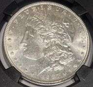 1887 NGC Brilliant Uncirculated Morgan $ With Original Bag Fragment.