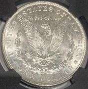 1887 NGC Brilliant Uncirculated Morgan $ With Original Bag Fragment.