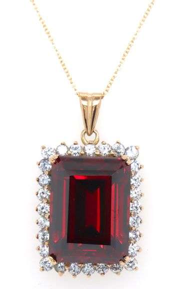 Emerald cut synthetic ruby and CZ halo frame pendant on chain in yellow gold
