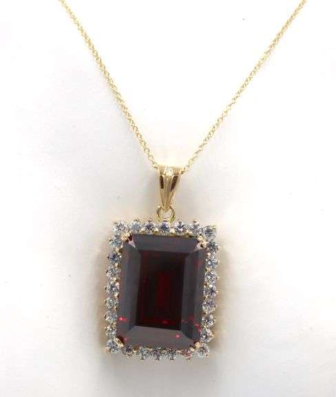 Emerald cut synthetic ruby and CZ halo frame pendant on chain in yellow gold