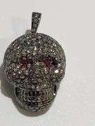 One 18kt black gold diamond and natural ruby skull pendent