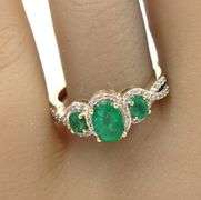 14kt Yellow gold 3 stone oval emerald and diamond halo ring
