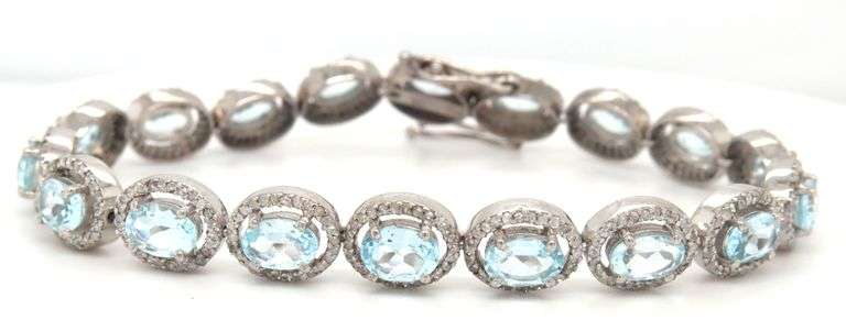 Sparkling 14.00CTW Oval Faceted Blue Topaz & 3.50CTW Diamond bracelet in 14K White Gold Over Sterlin