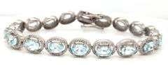 Sparkling 14.00CTW Oval Faceted Blue Topaz & 3.50CTW Diamond bracelet in 14K White Gold Over Sterlin