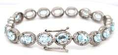 Sparkling 14.00CTW Oval Faceted Blue Topaz & 3.50CTW Diamond bracelet in 14K White Gold Over Sterlin