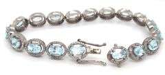 Sparkling 14.00CTW Oval Faceted Blue Topaz & 3.50CTW Diamond bracelet in 14K White Gold Over Sterlin